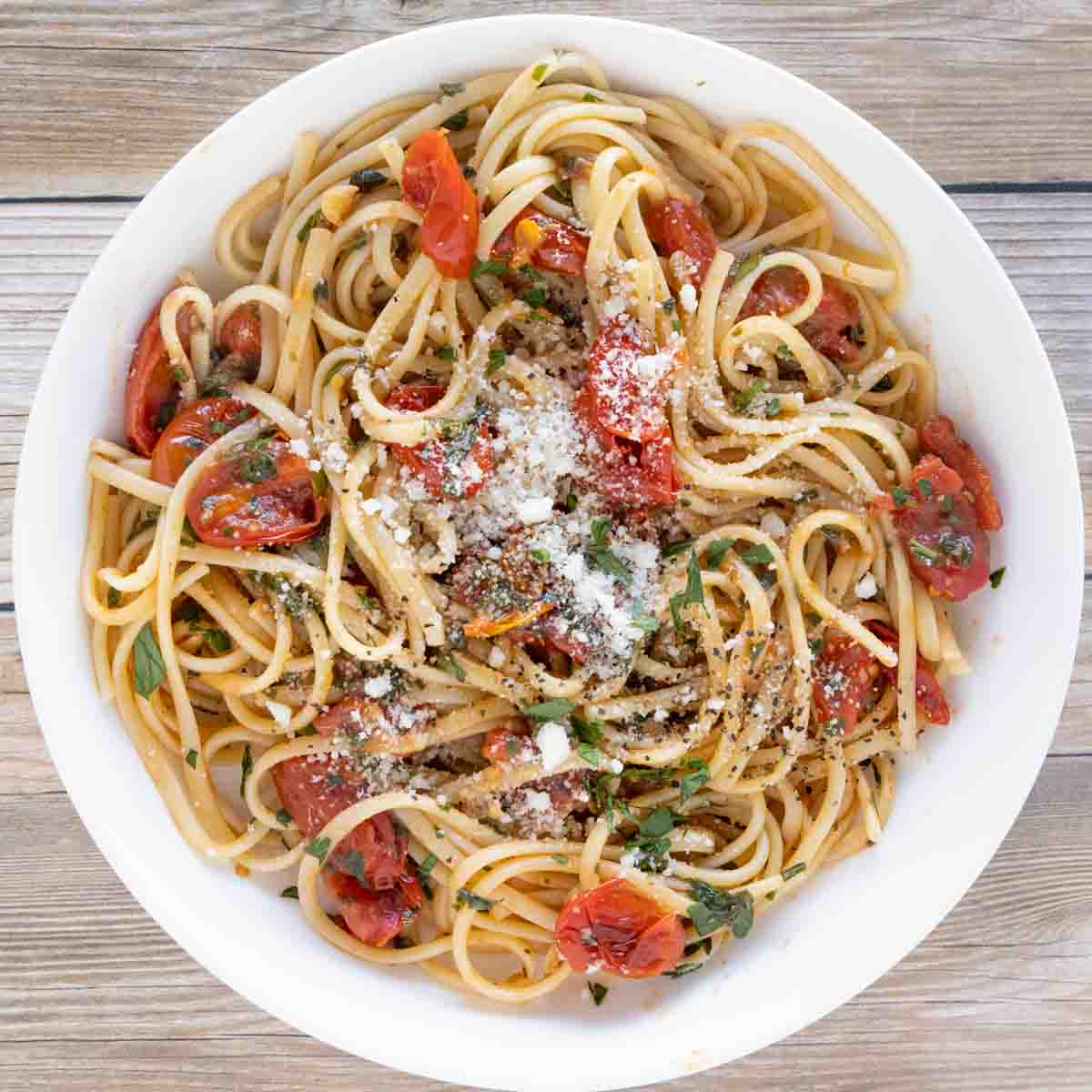 tomato basil pasta in a white bowl.