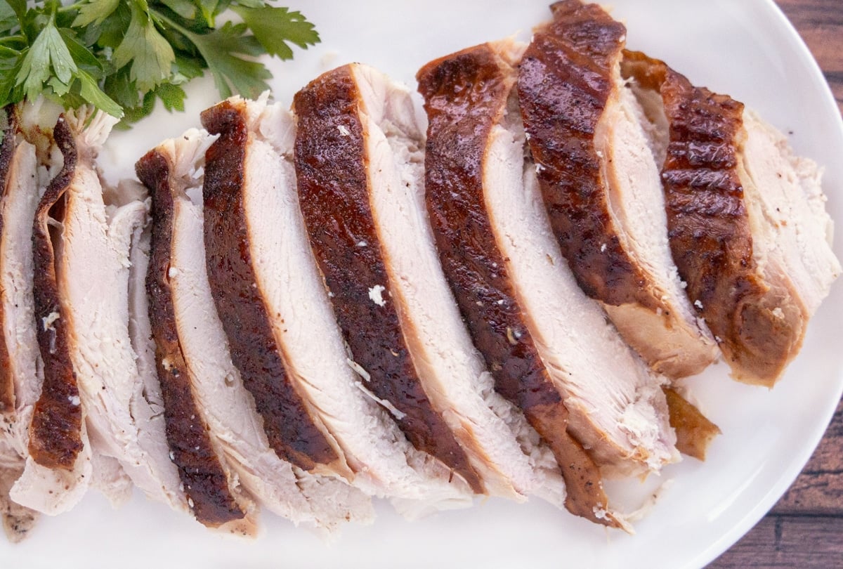 sliced smoked turkey breast on a white platter