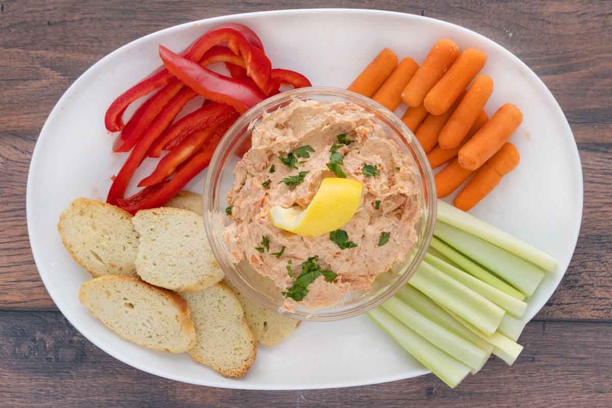 Smoked trout dip on a white platter with vegetables.