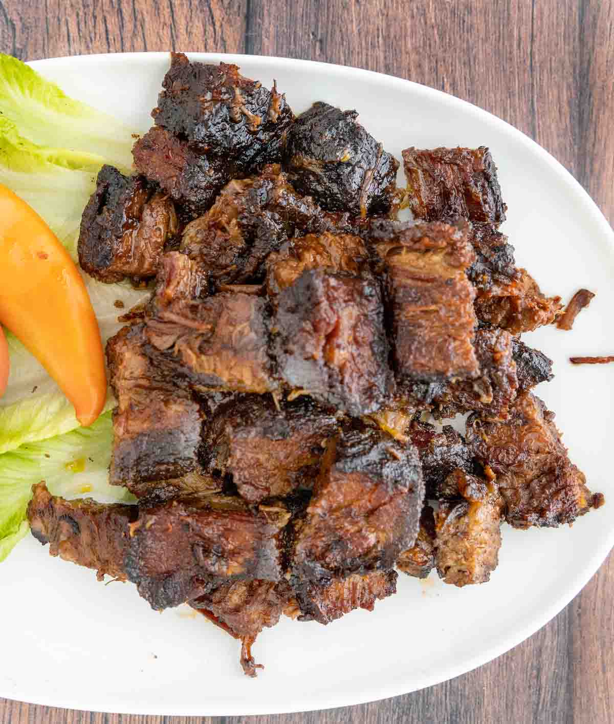 smoked beef brisket burnt ends on a white platter.