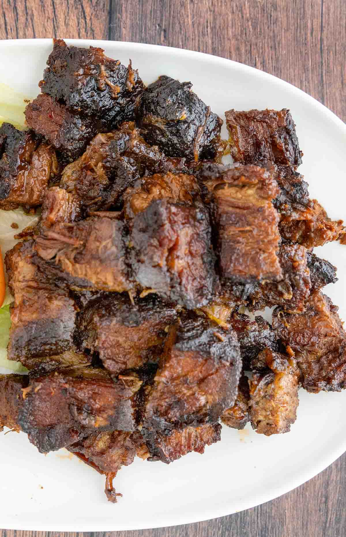 smoked beef brisket burnt ends on a white platter.