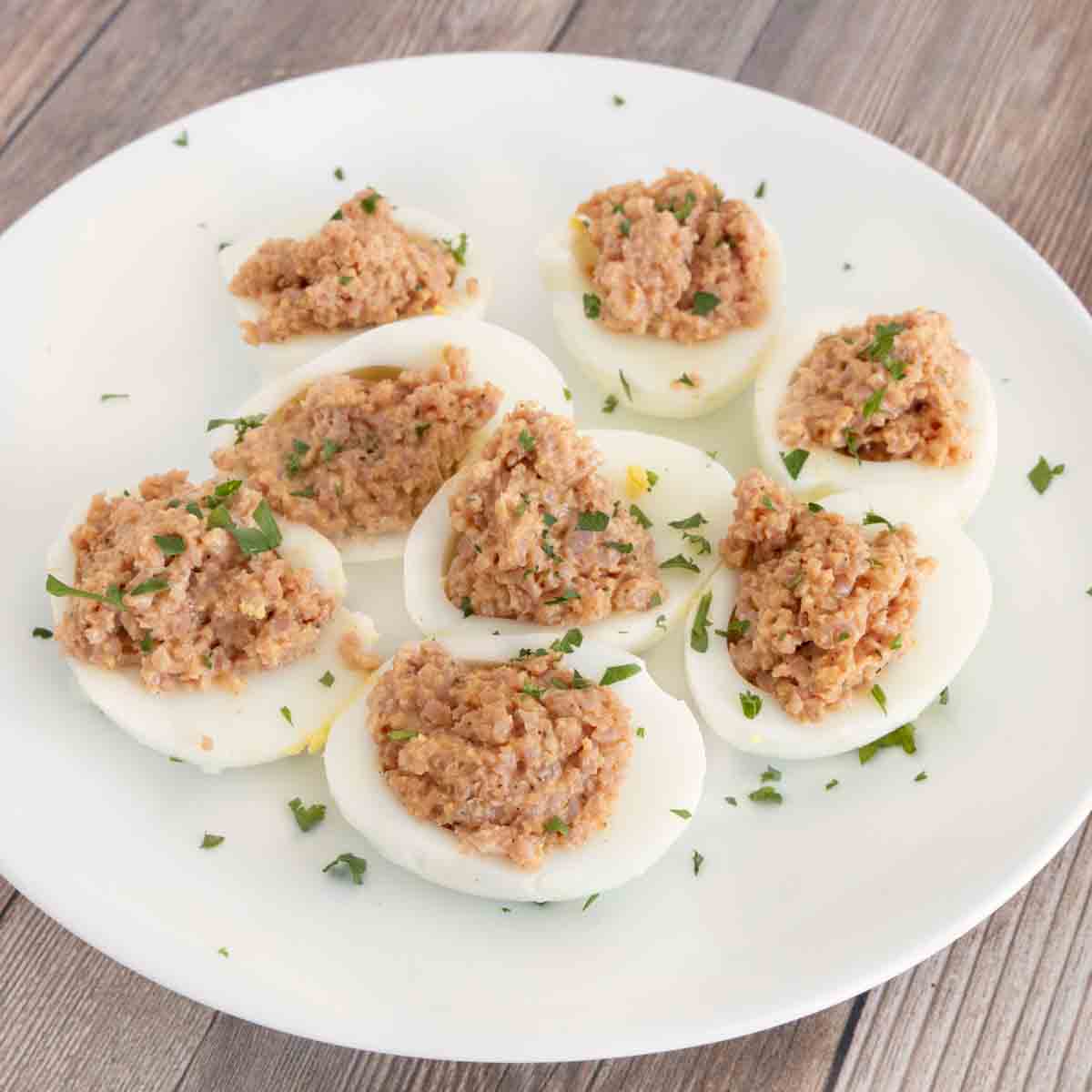 Deviled ham eggs on a white plate.