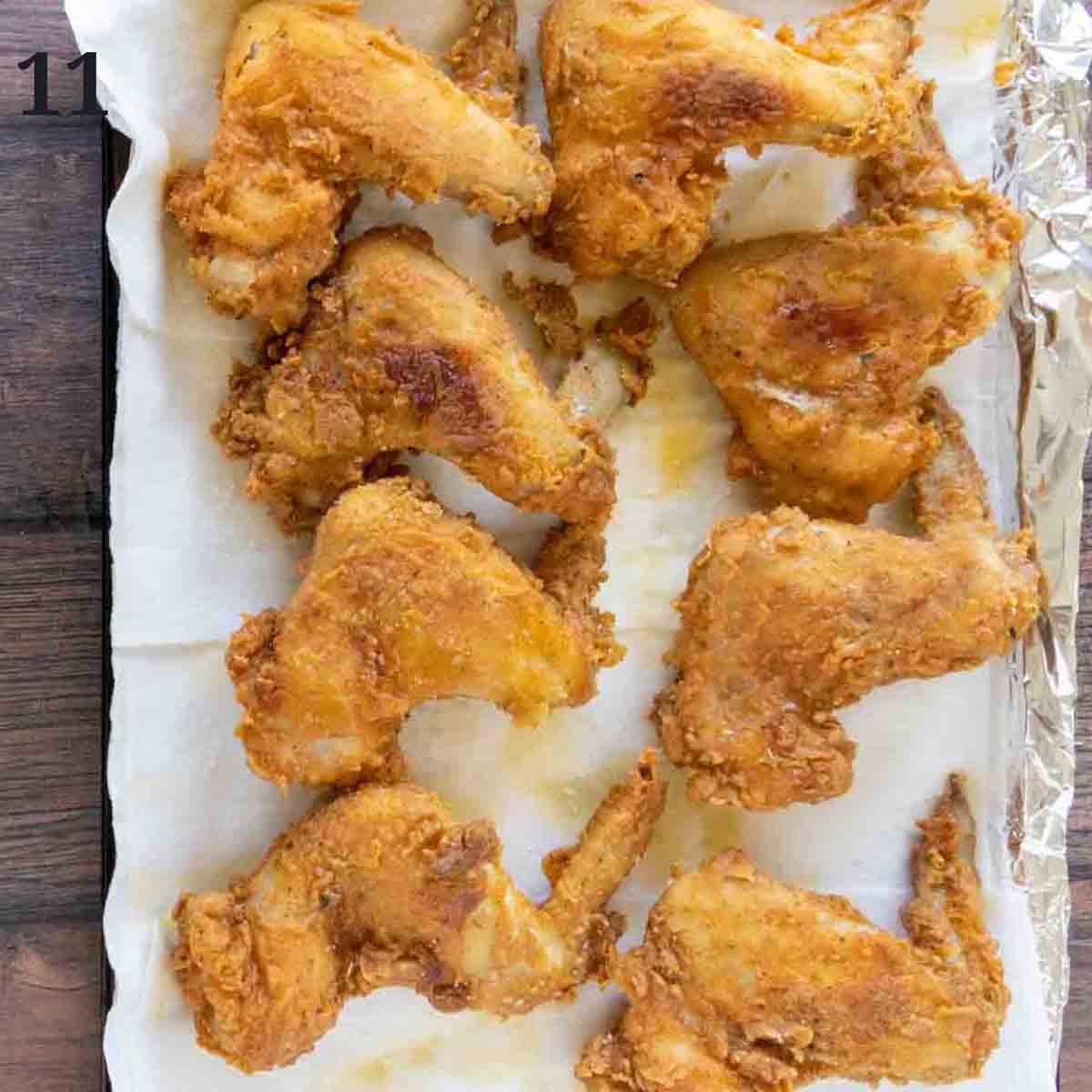 Fried chicken wings draining on paper towels.