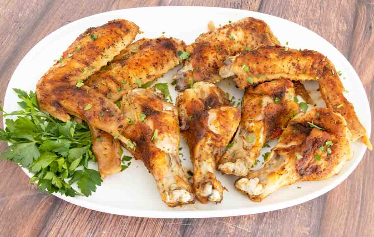 Baked turkey wings on white platter.