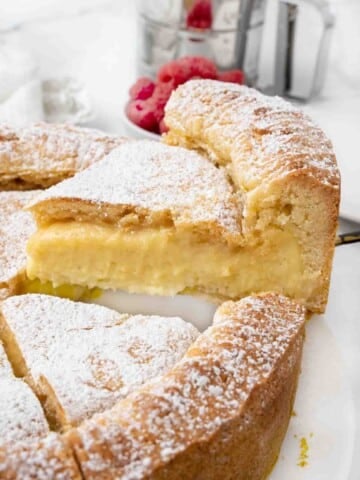 Slice of Gateau Basque being taken out of whole cake.