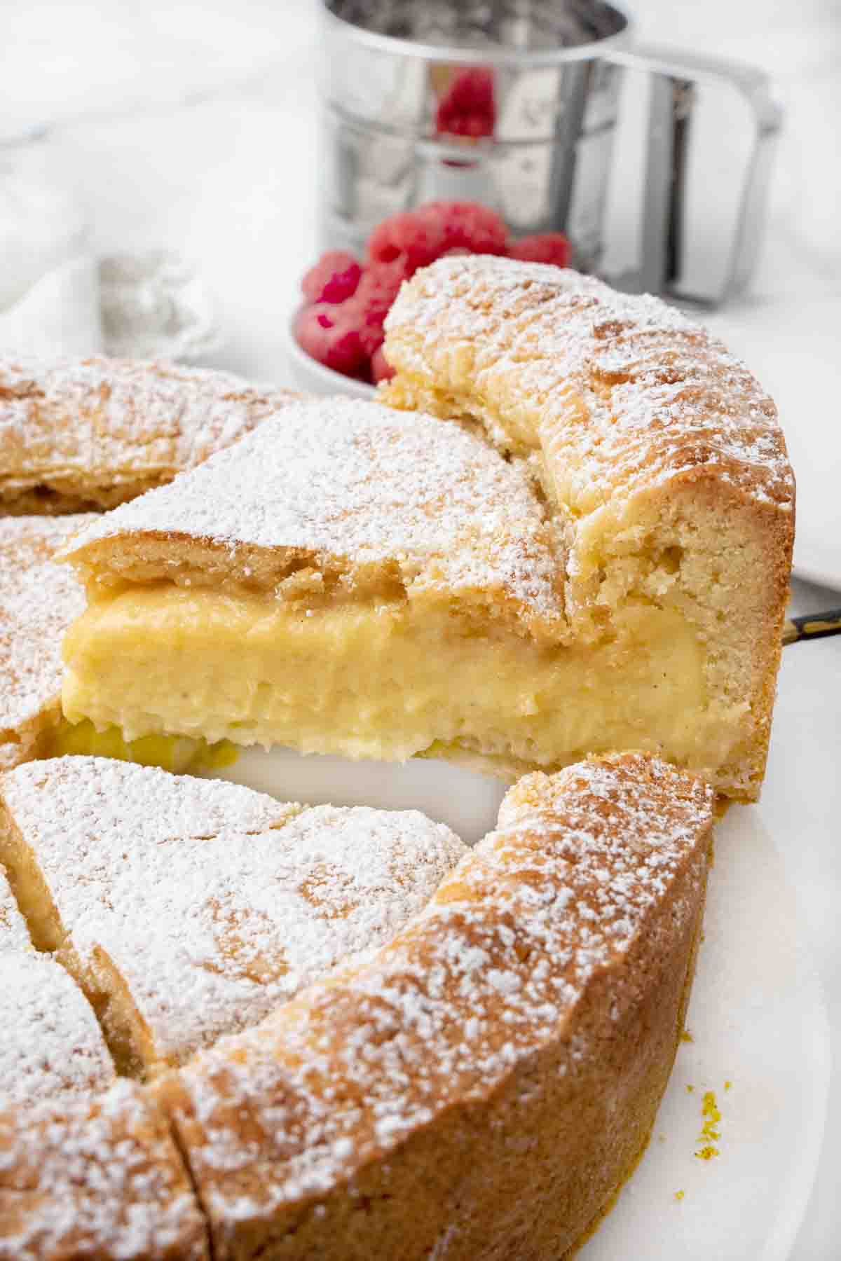 Slice of Gateau Basque being taken out of whole cake.