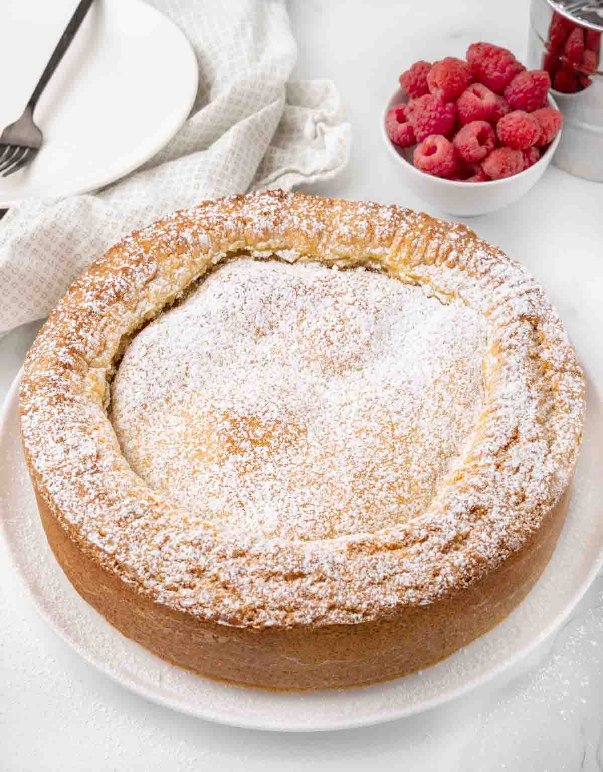 Whole Gateau Basque on a white platter.