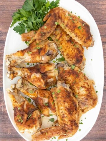 Baked turkey wings on white platter.