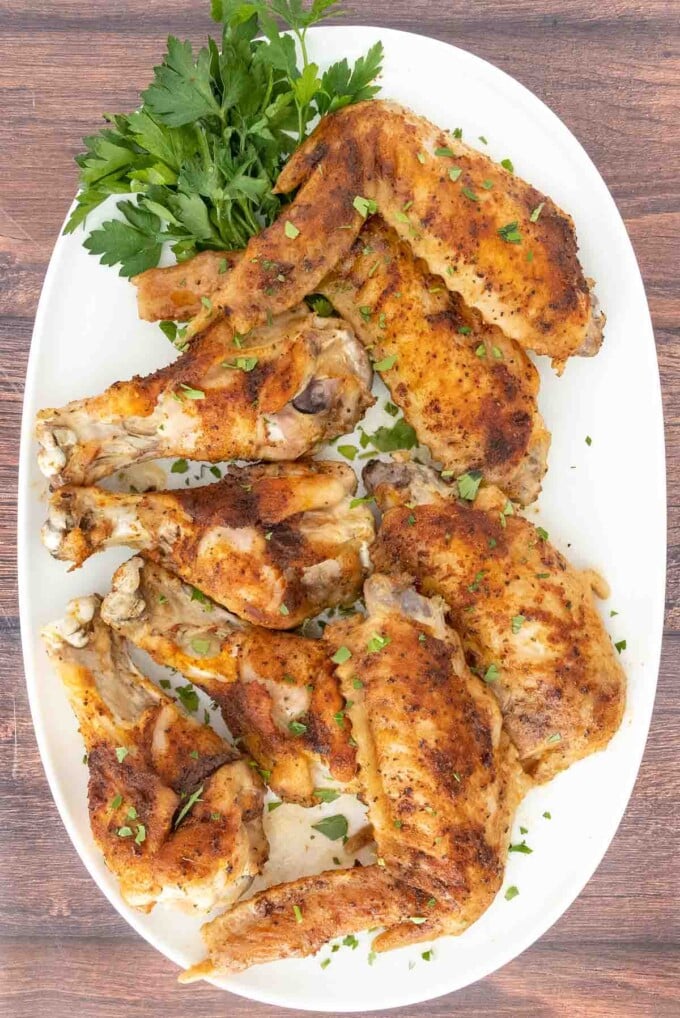 Baked turkey wings on white platter.