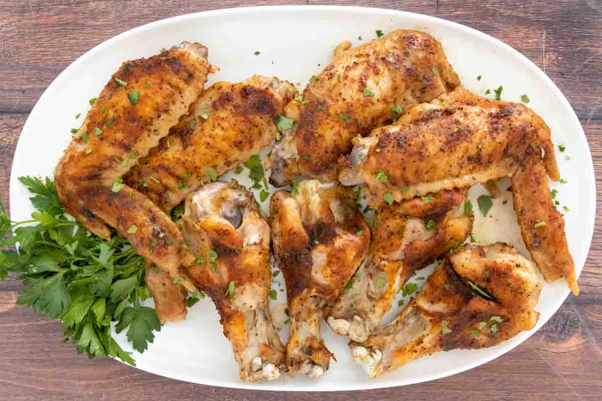 Baked turkey wings on white platter.