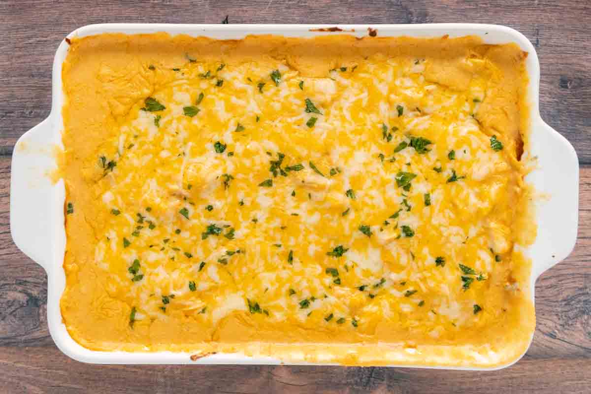 Baked slow cooker Buffalo chicken dip in a white casserole dish.