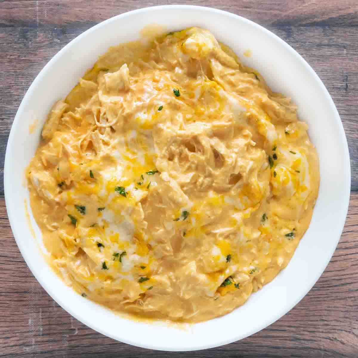 Slow cooker Buffalo chicken Dip in a white bowl.