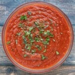 slow cooker spaghetti sauce in a bowl with a sprinkle of chopped basil.