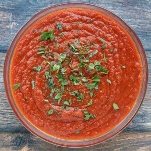 slow cooker spaghetti sauce in a bowl with a sprinkle of chopped basil.