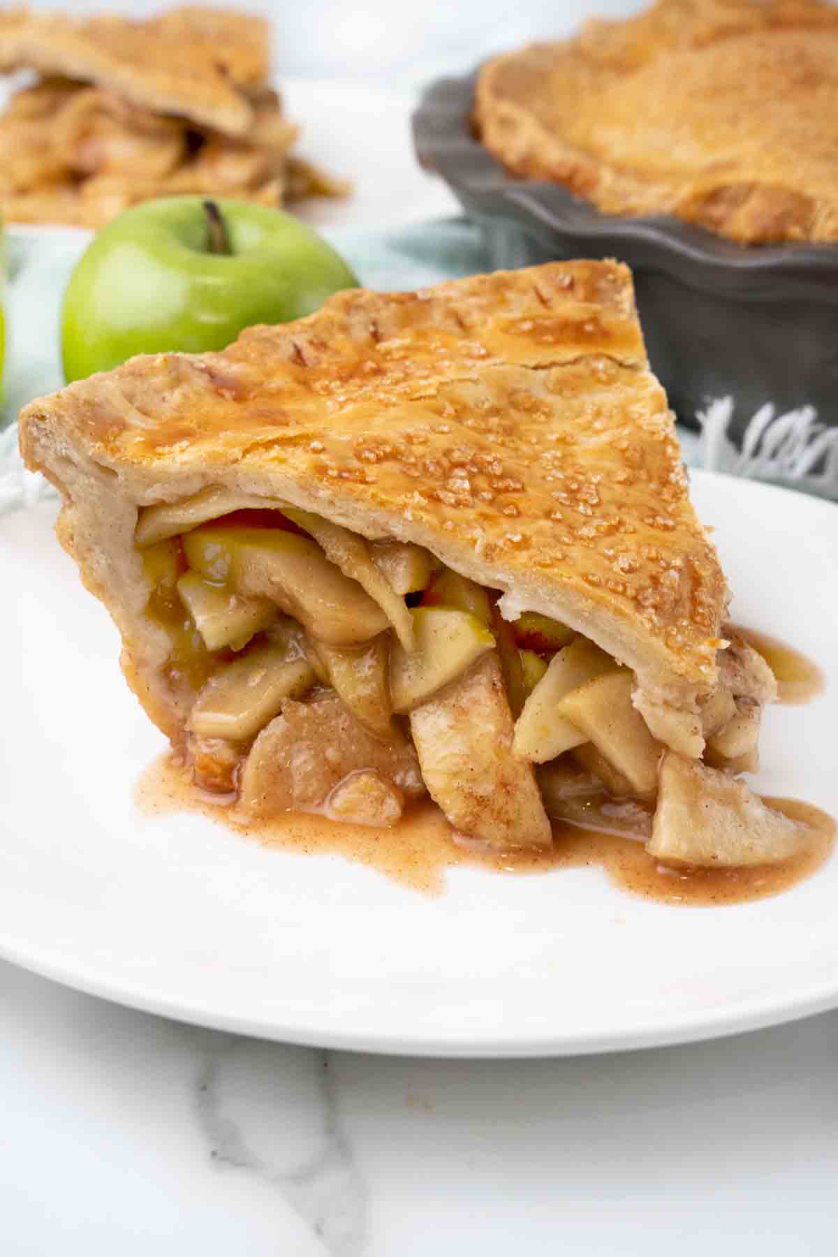 Slice of apple pie on a white plate.