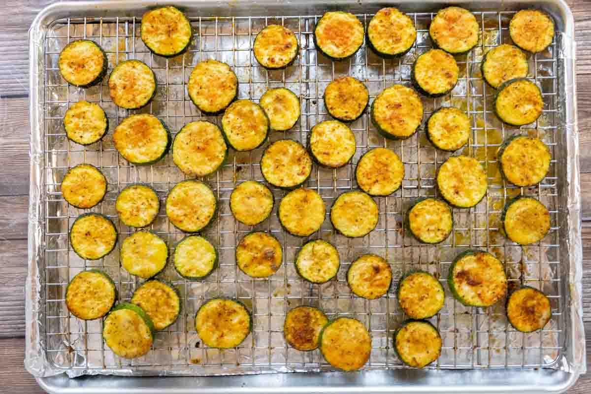 Fully cooked oven roasted zucchini slices on baking sheet.