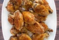 Crispy chicken wings on a white platter.