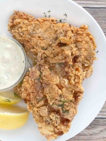 Crispy fried catfish on a white plate.