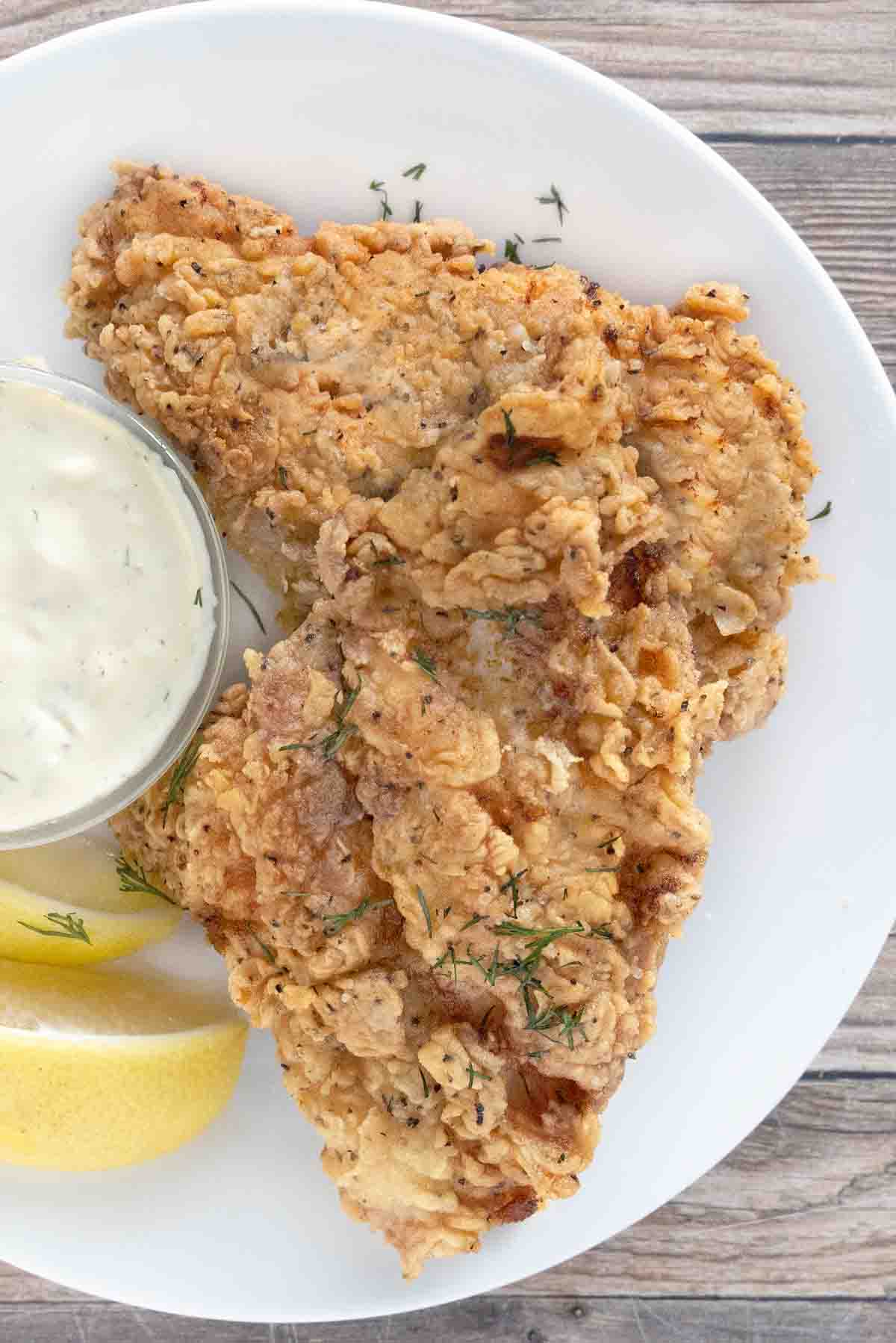 Crispy fried catfish on a white plate.