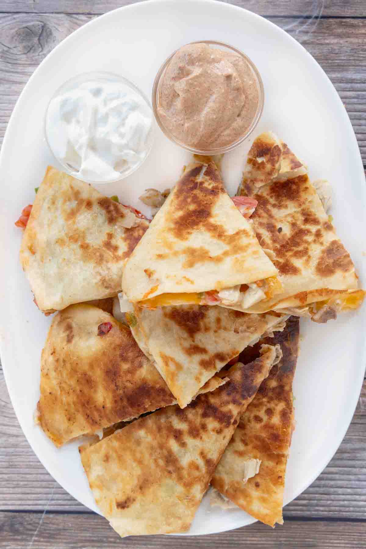 Chicken quesadillas on a white platter.