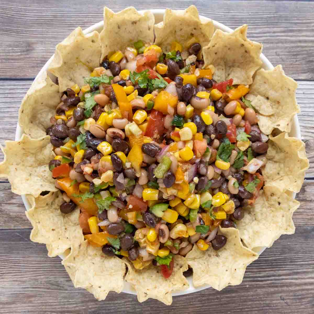 Texas caviar with tortilla chips in a bowl.