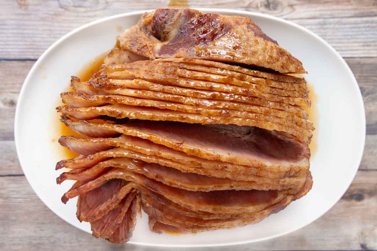 glazed slow cooker spiral ham on a white platter.