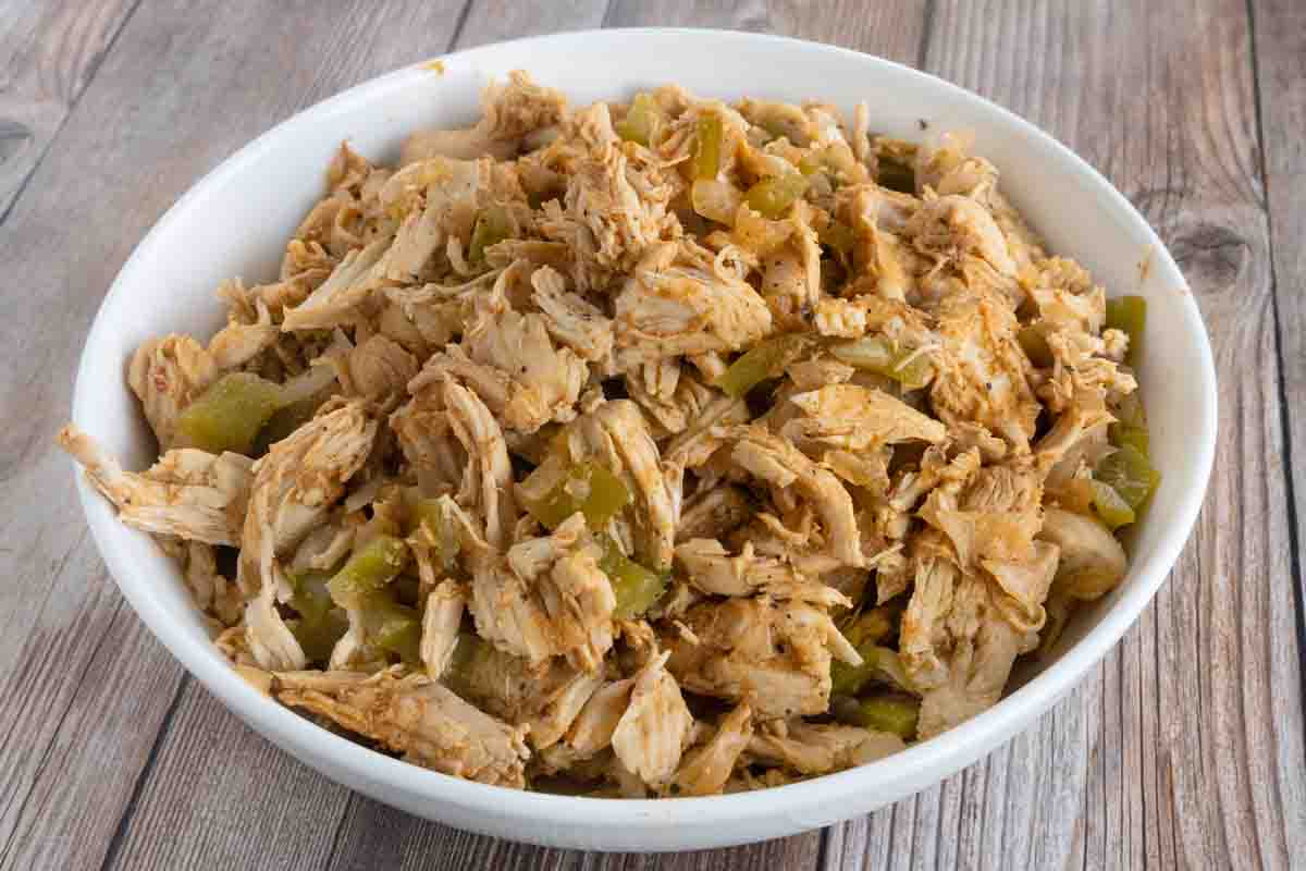 slow cooker shredded chicken in a white bowl.