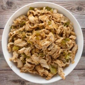 slow cooker pulled chicken in a white bowl.