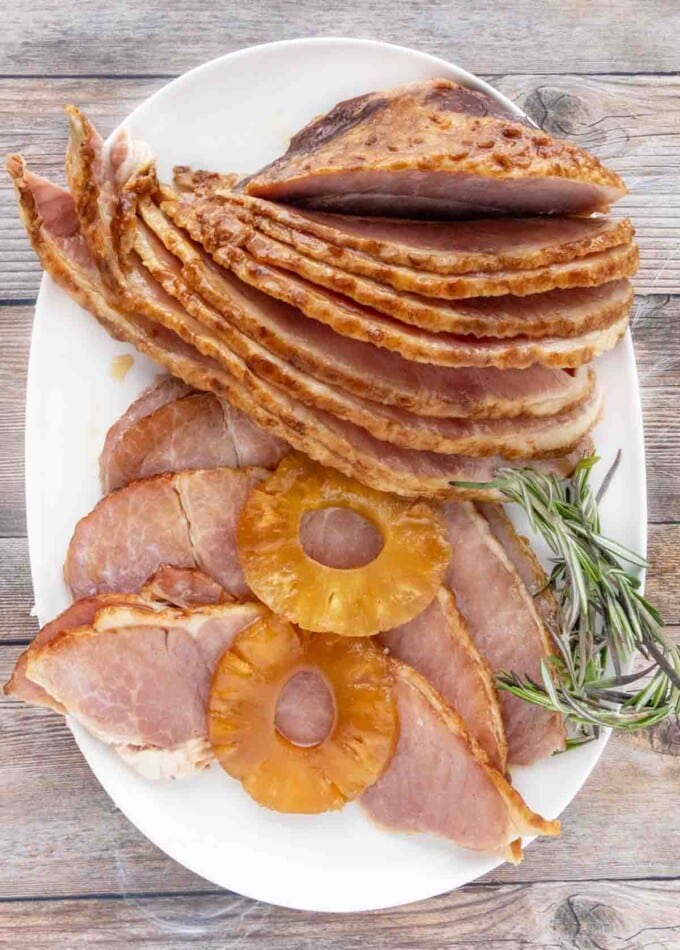 slow cooker ham slices with pineapple slices on a white platter.