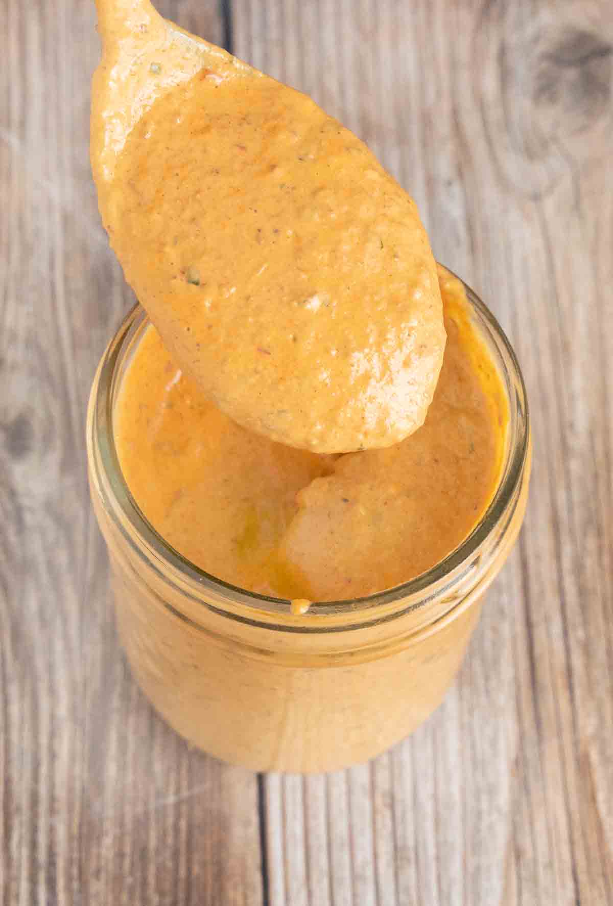 Chipotle pepper sauce in mason jar with spoon coming ut of the jar.