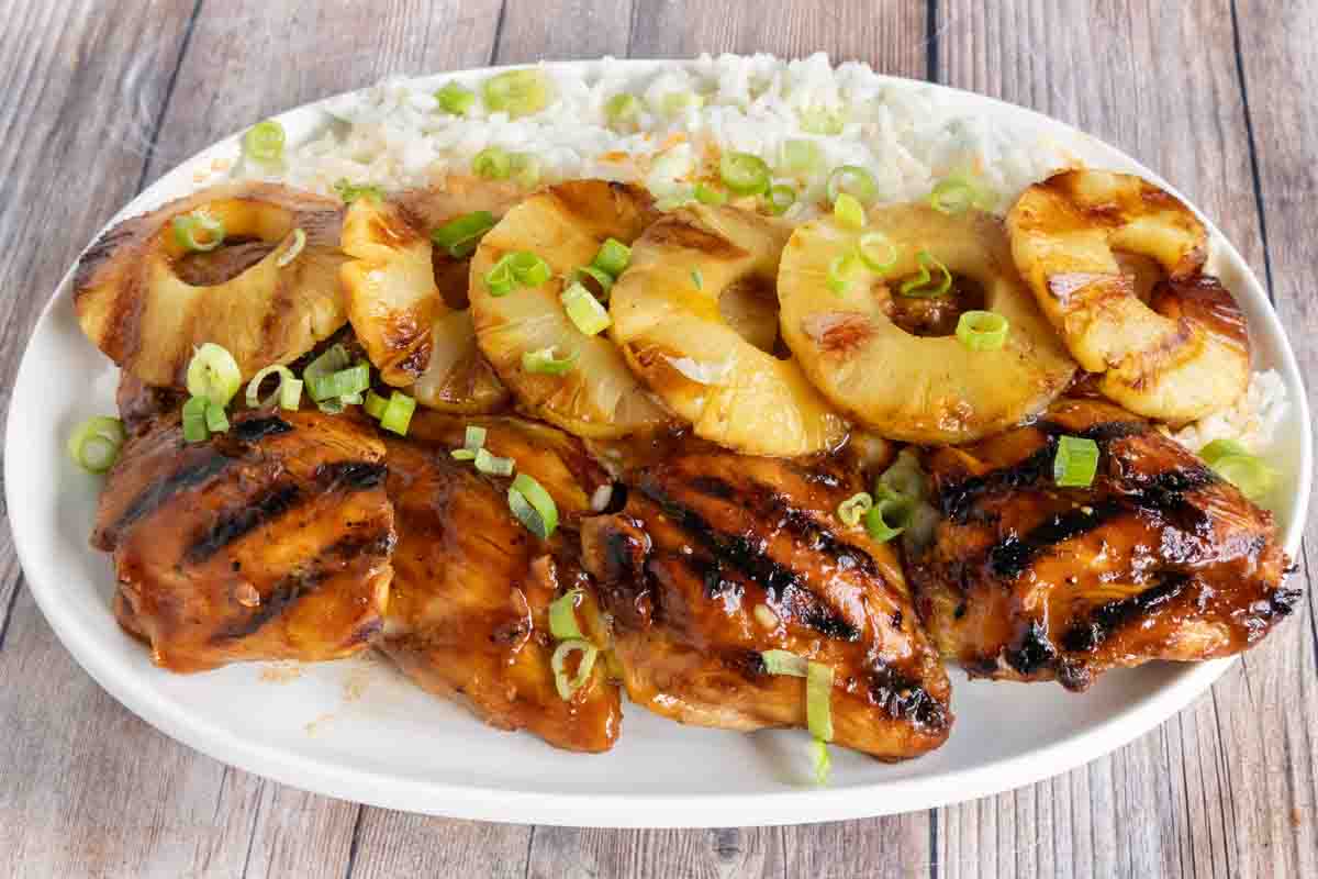 Huli Huli chicken with pineapple and rice on white platter