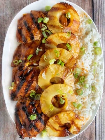 Huli Huli chicken with pineapple and rice on white platter.