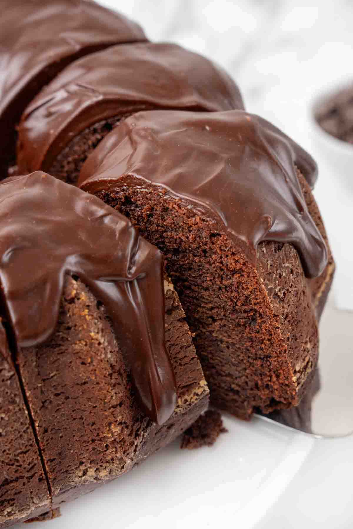 slice of chocolate brownie cake being taken out of whole cake.