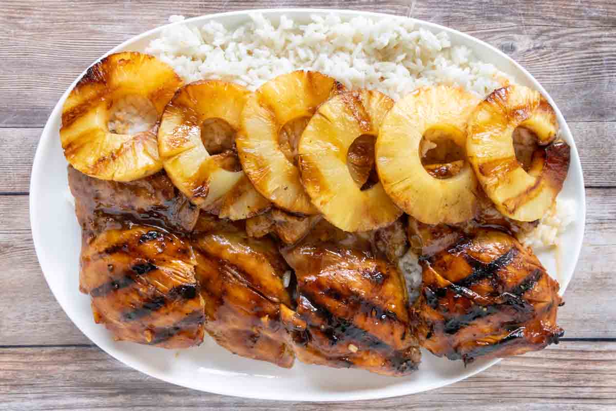 Huli Huli chicken with pineapple and rice on white platter