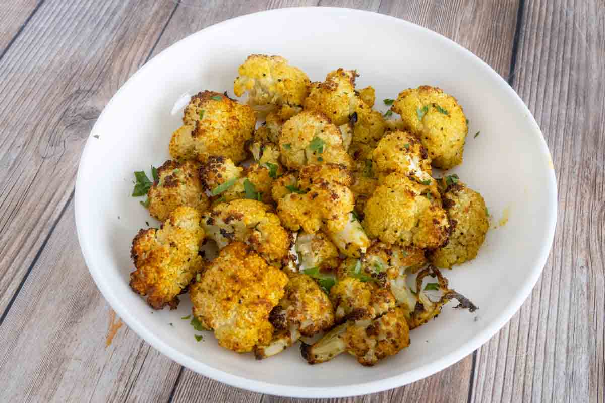 Oven roasted cauliflower in a white bowl.
