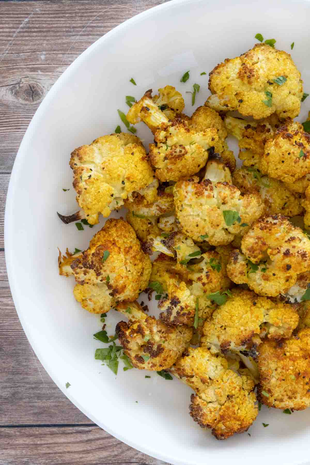 Oven roasted cauliflower in a white bowl.