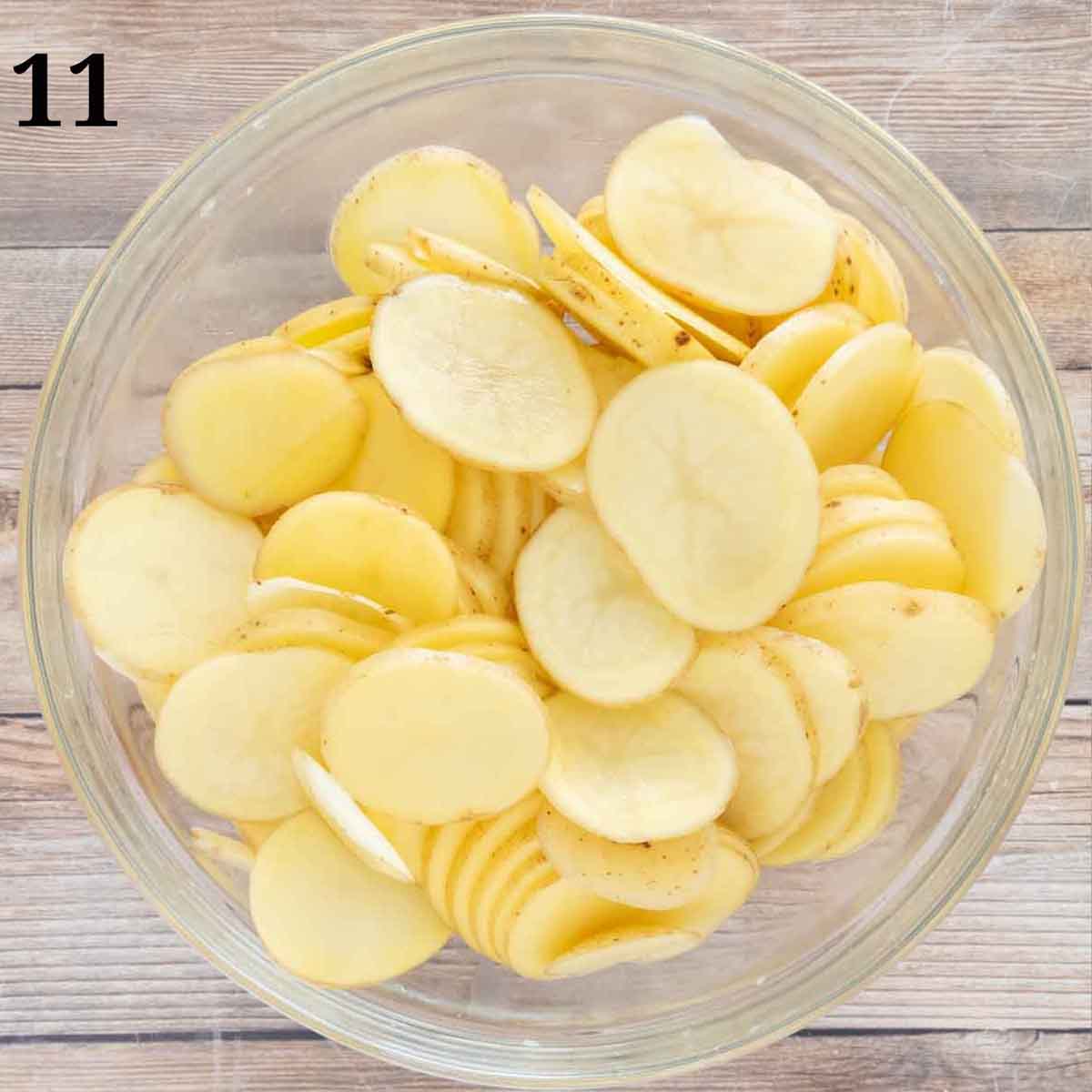 Sliced potatoes in a glass bowl.