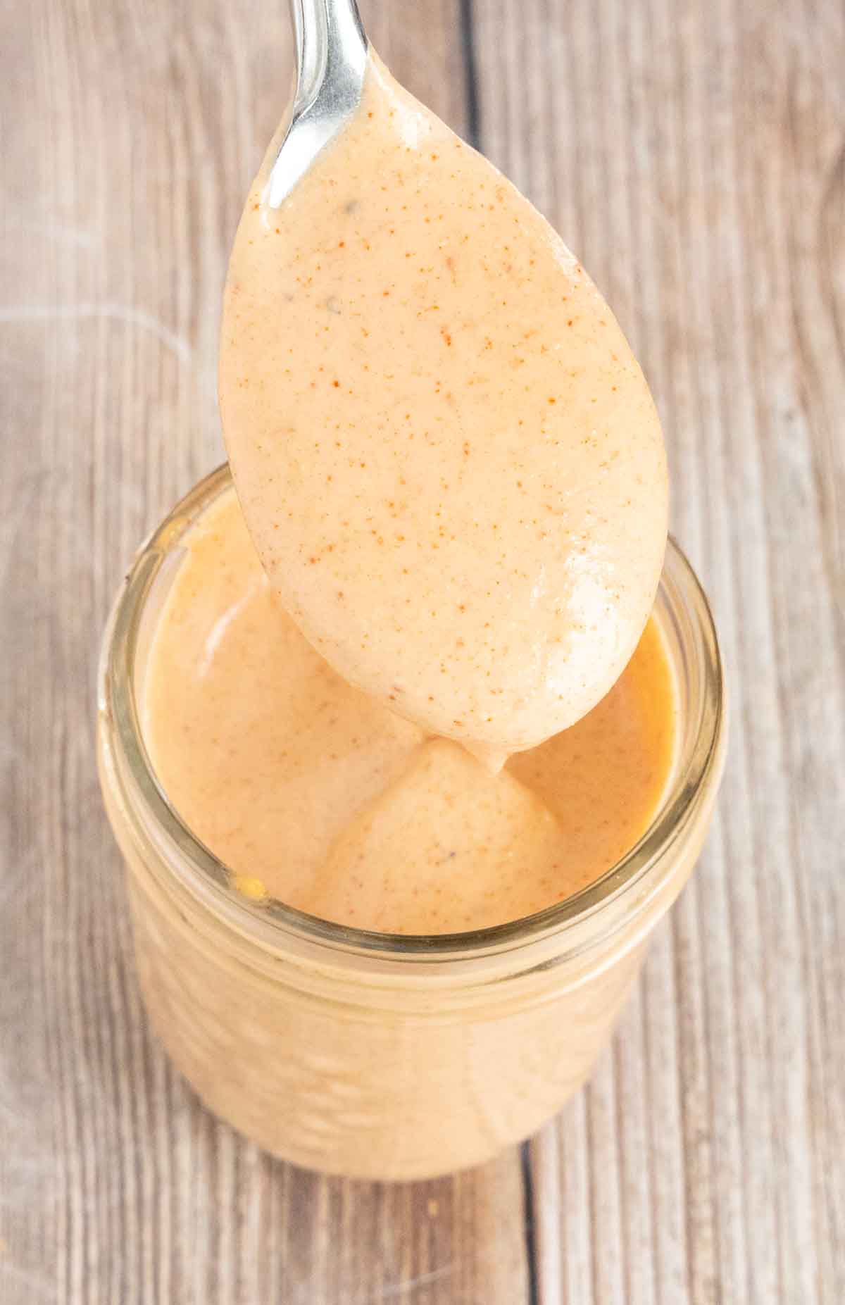 Yum Yum sauce in a glass jar with a spoon coming out of the jar.