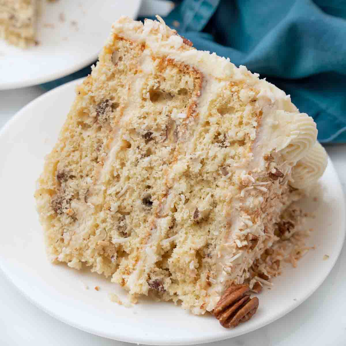 Slice of Italian cream cake on a white plate.