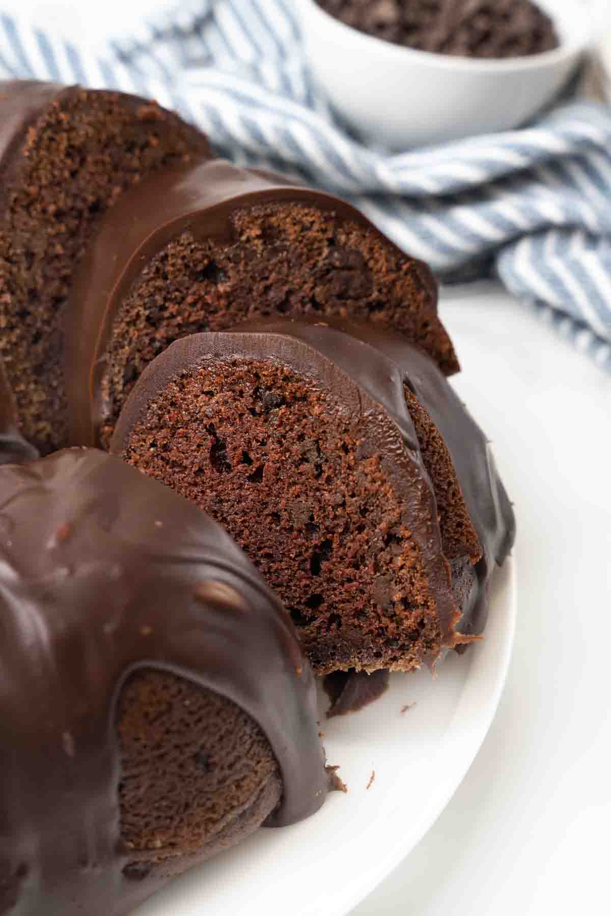 Slice of chocolate bundt cake being taken out of the whole cake.