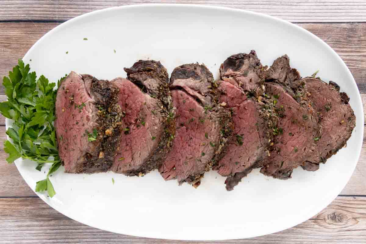 Sliced roasted beef tenderloin on a white platter