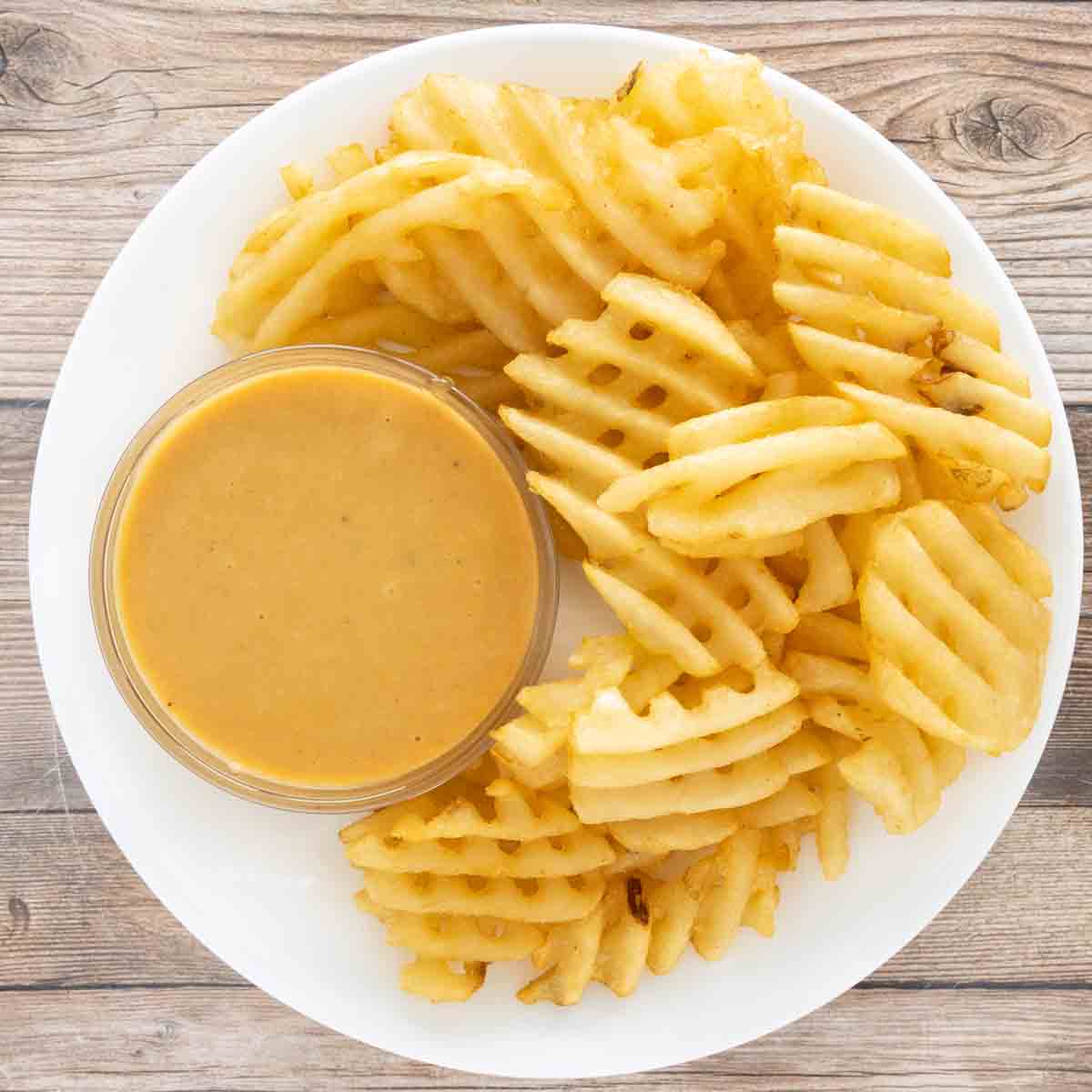 The sauce with waffle fries in a white bowl.