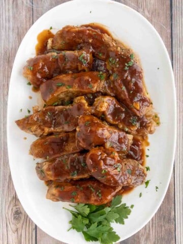 Slow cooker country style pork ribs on a white platter.