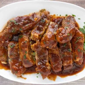 Slow cooker country style pork ribs on a white platter.