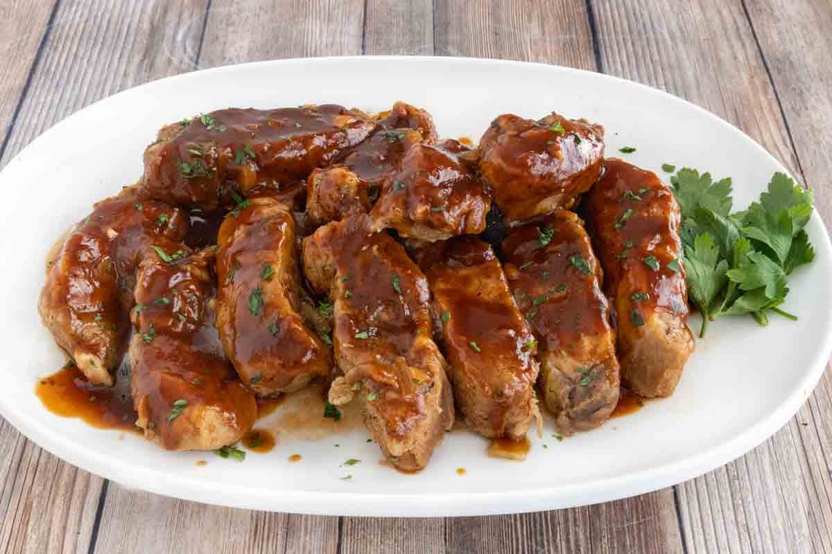 Slow cooker country style pork ribs on a white platter.