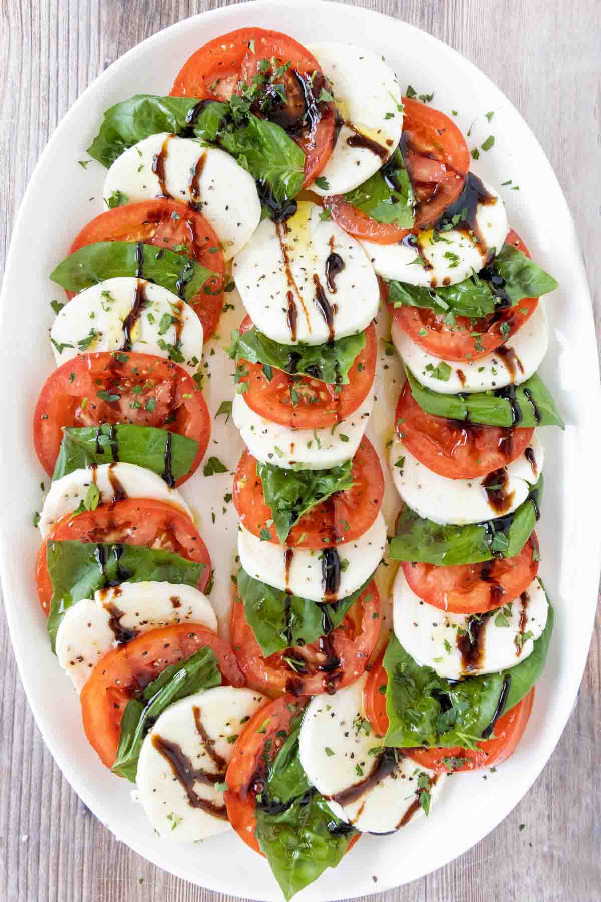 Caprese salad on a white platter.