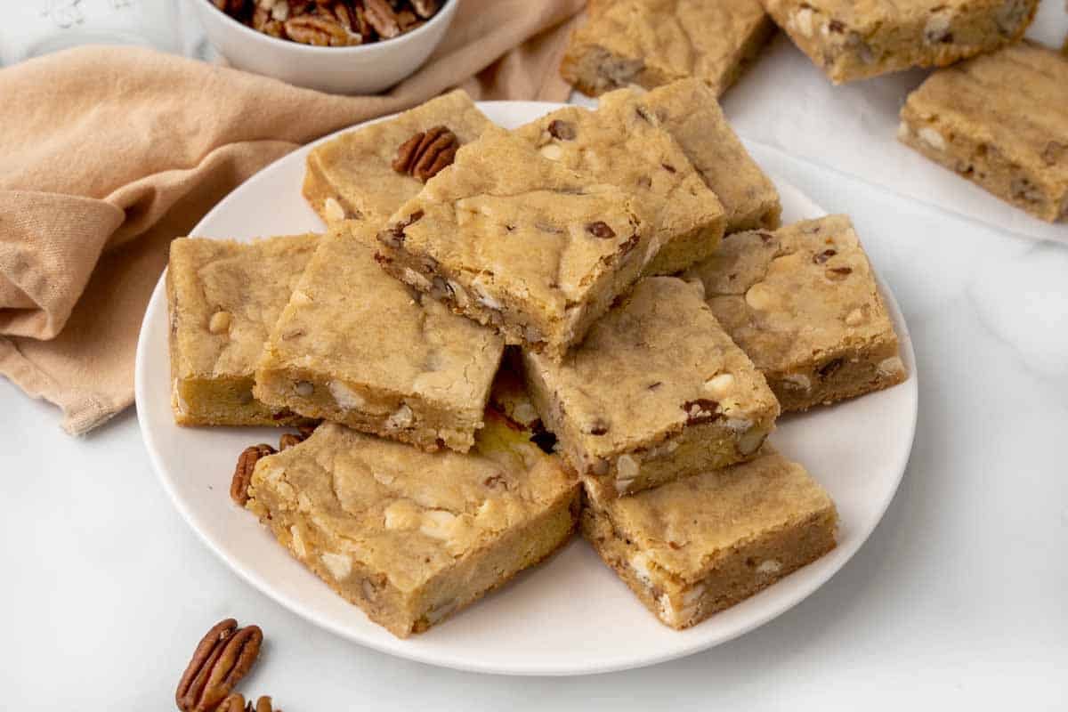 Blondies stacked on a white platter.