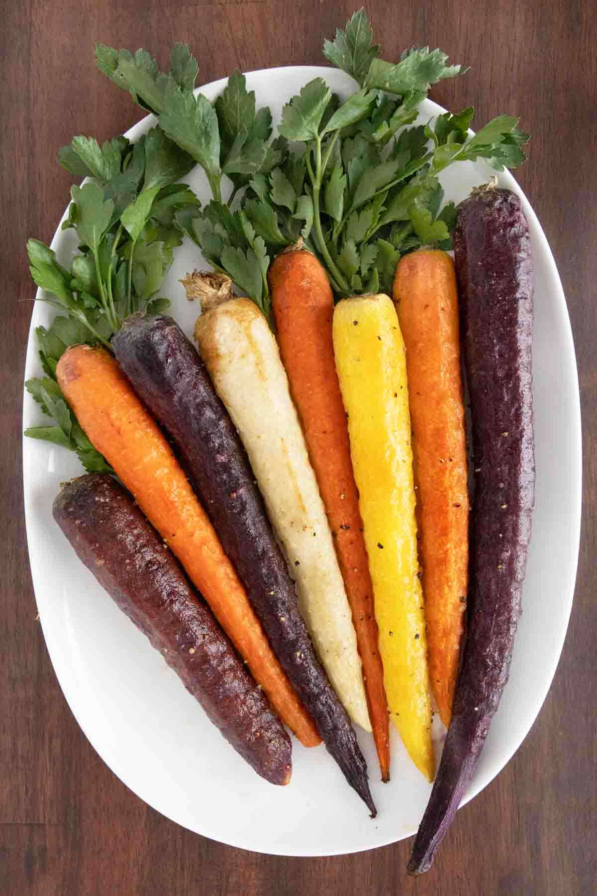 Oven roasted carrots on a white platter.