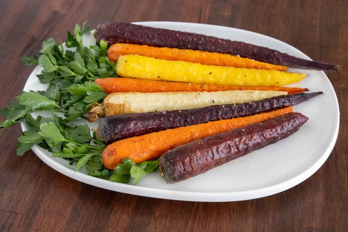 Oven roasted carrots on a white platter.