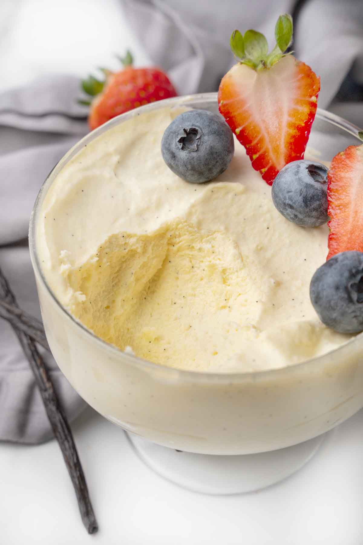 Bavarian cream in a dessert glass garnished with berries, with a spoonful taken out.